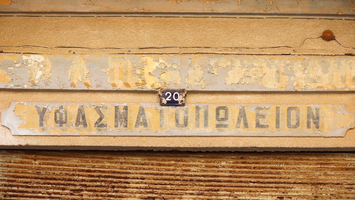 Aged shop sign with peeling paint in Gazimağusa, offering a vintage look.